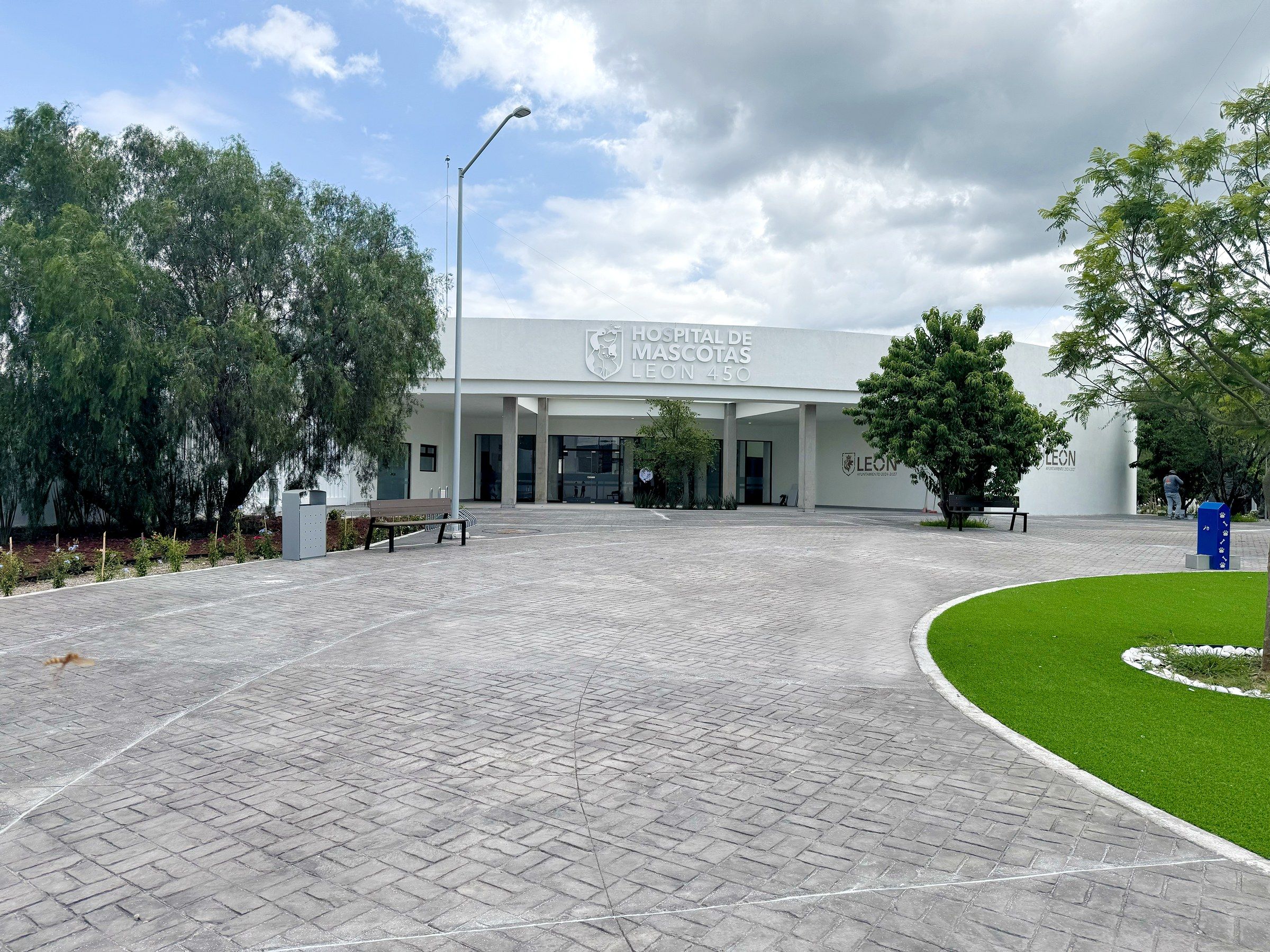 Fachada del Hospital de Mascotas, edificio blanco con jardinera al frente.